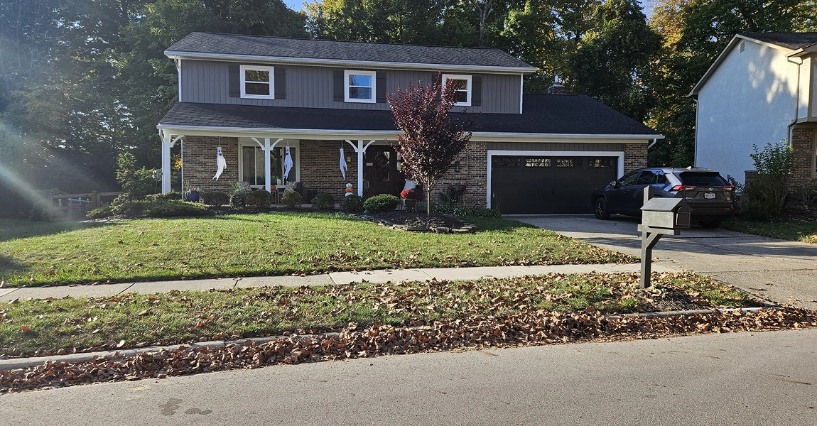 Worthington, OH home with new vertical vinyl siding panels installed by Columbus Windows & Siding under sunny skies.